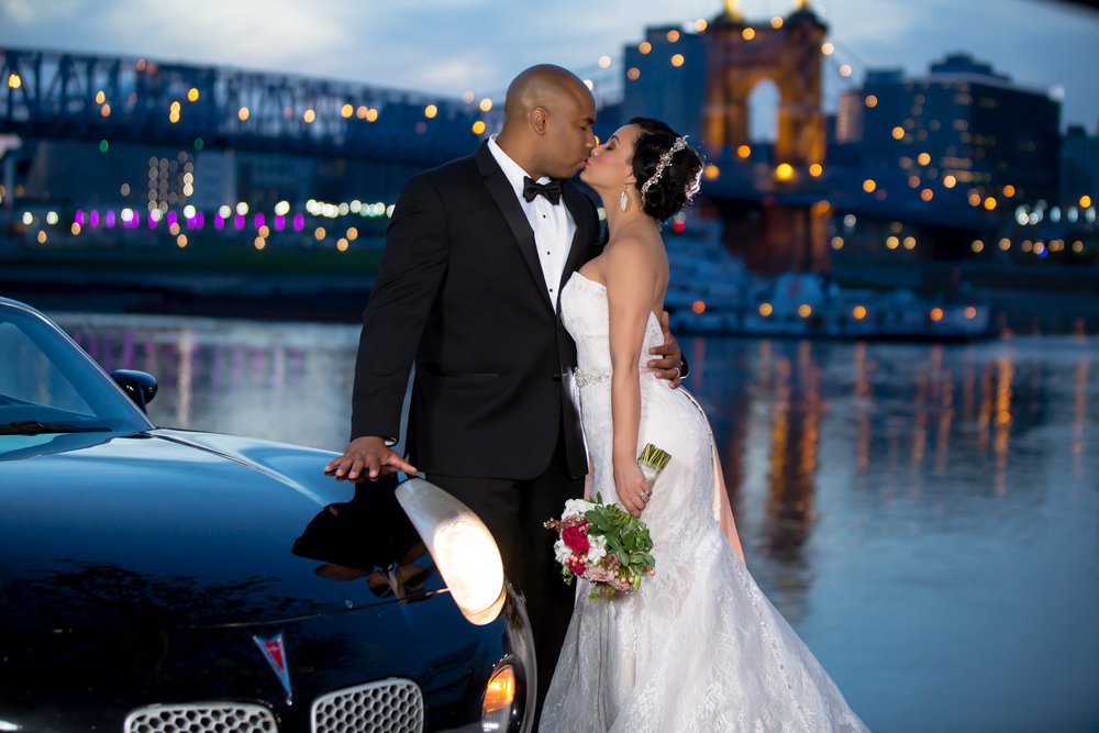 bride and groom in front of cincinnati river